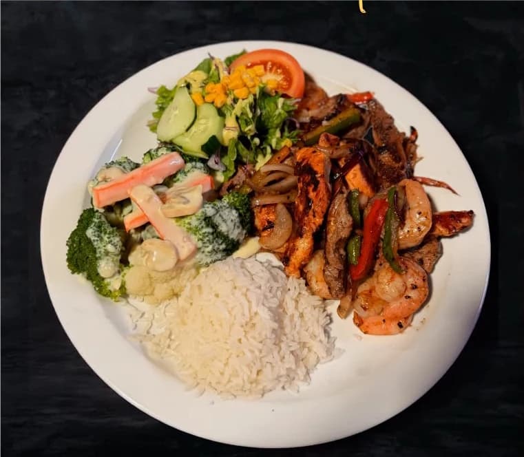 Fajitas trío de Marlon Restaurante: lomito, pollo y camarón con chile y cebolla, arroz y ensalada.