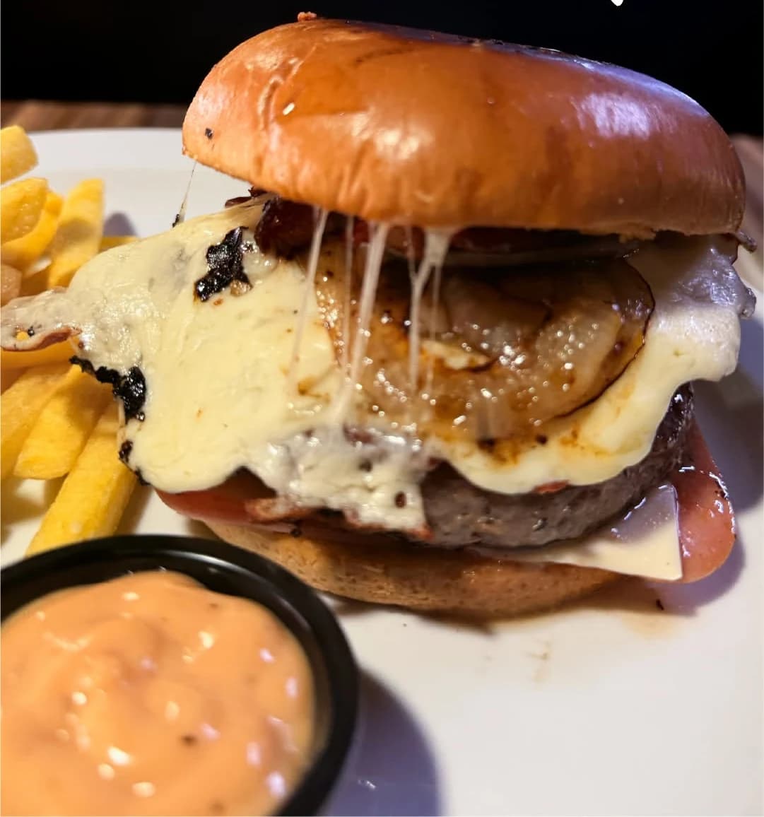 Hamburguesa de res de Marlon Restaurante, con queso derretido, tocineta y papas fritas.